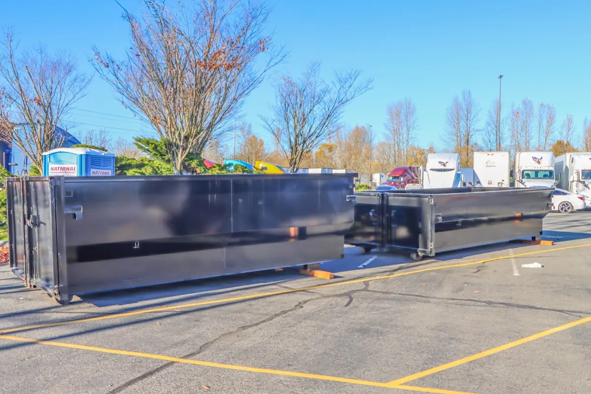 Professional dumpster rental service with roll-off container on residential driveway in Kinross